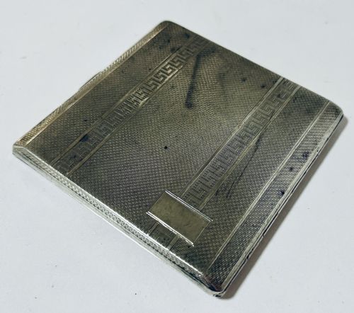 fig 2. An Art Deco silver rectangular cigarette case featuring engine-turned geometric patterning and a small rectangular vacant cartouche.