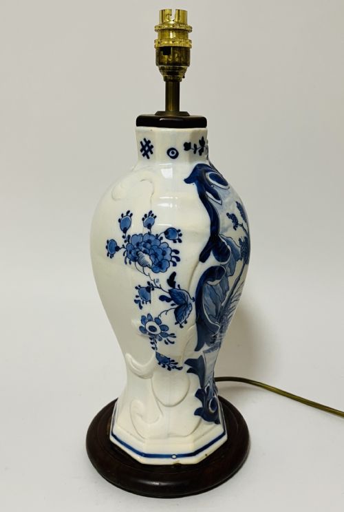 fig 2. An 18th-century baluster-shaped Delftware ceramic vase decorated with blue and white pastoral scenes, mounted on a dark wooden plinth as a table lamp with brass fittings.