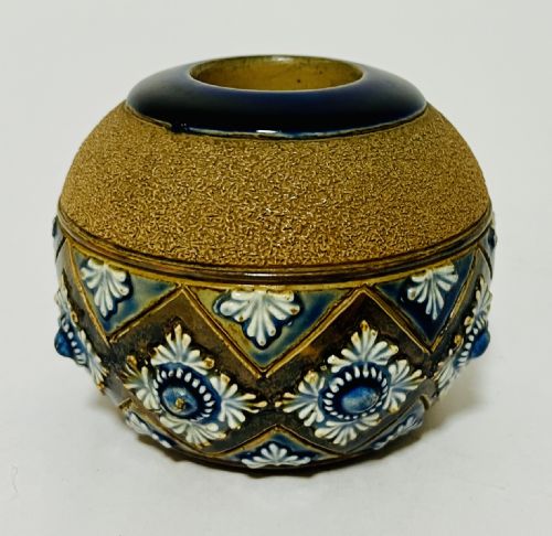 fig 1. A spherical Doulton Lambeth stoneware match striker featuring a textured upper striking band and a cobalt blue diamond lattice lower section with raised white rosette motifs.