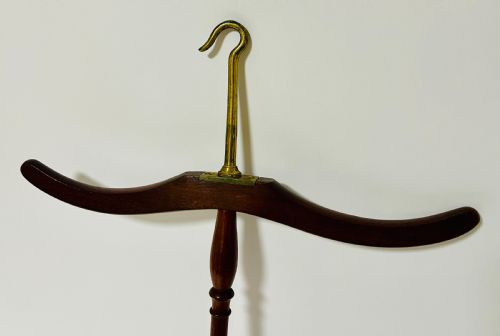 fig 1. An antique dark mahogany gown and wig hanger featuring a contoured wooden shoulder bar, a turned central spindle, and a brass hook.