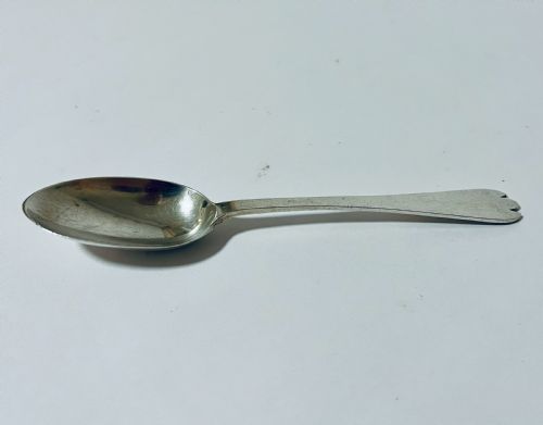 fig 1. An antique silver trefid spoon featuring a shallow oval bowl and a flat stem terminating in a distinctive notched three-pointed shape.