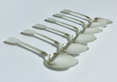 fig 1. A set of six Georgian sterling silver tablespoons with oval bowls and engraved initial terminals laid out diagonally.