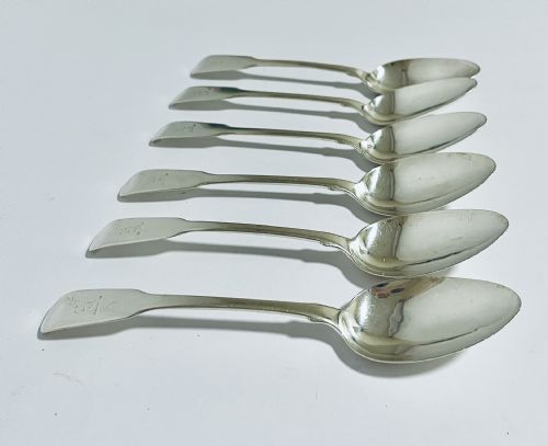fig 2. A set of six Georgian sterling silver tablespoons with oval bowls and engraved initial terminals laid out diagonally.