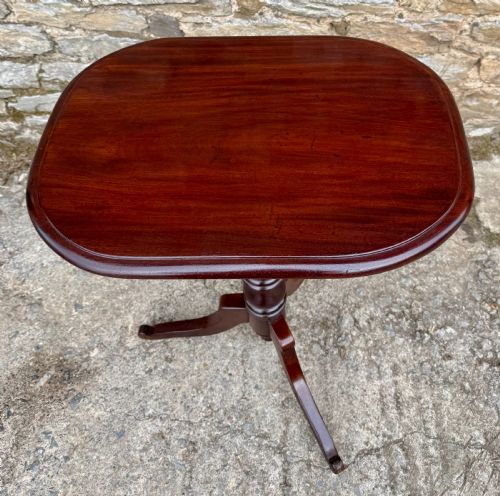 fig 1. A Victorian dark mahogany wine table featuring a rounded rectangular top, a central turned baluster column, and a tripod base.