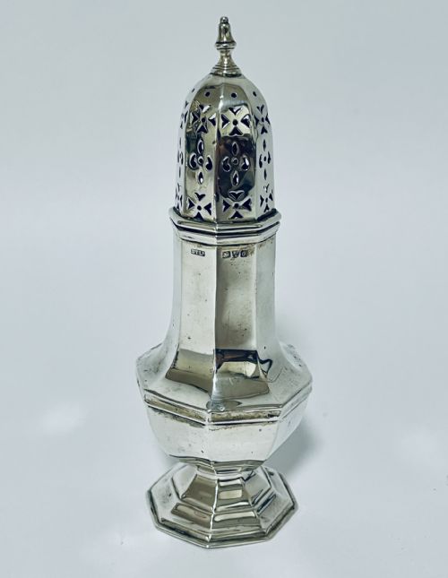 fig 1. An octagonal sterling silver sugar caster featuring a hand-pierced dome cap, finial top, and engraved presentation inscription on the base.