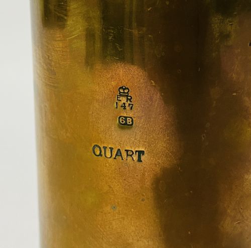 fig 1. A cylindrical Victorian brass quart measure featuring a rolled rim and official stamped verification marks alongside the word QUART.