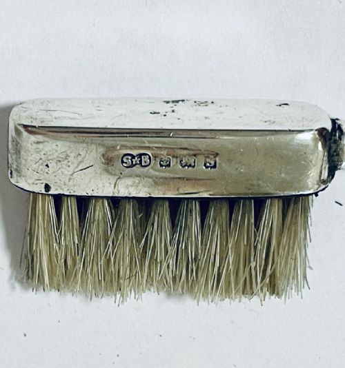 An antique silver moustache brush featuring a textured handle with a central circular cartouche and visible silver hallmarks stamped on the brush head. View IV