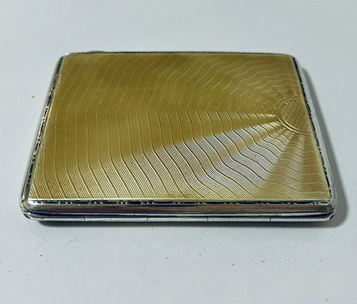 fig 1. An Art Deco rectangular silver cigarette case featuring a pale yellow translucent enamel panel over a sunburst guilloche pattern.