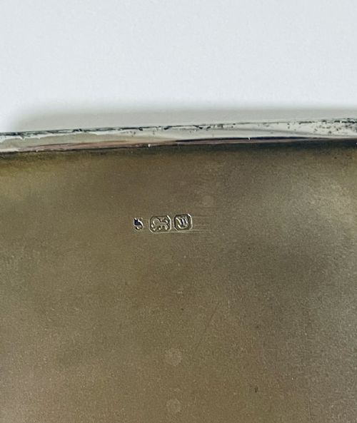 An Art Deco rectangular silver cigarette case featuring a pale yellow translucent enamel panel over a sunburst guilloche pattern. View VIII