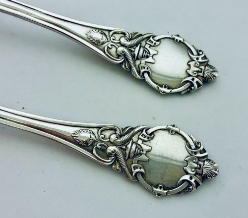 fig 3. An antique Victorian silver christening spoon and fork with intricate foliate engraving, arranged inside a velvet-lined dark leather presentation case.