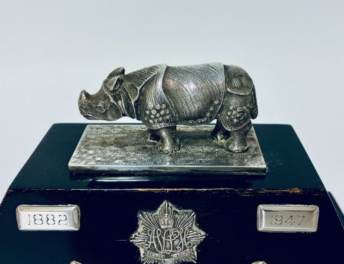 fig 1. An antique silver presentation trophy featuring a detailed Indian rhinoceros figurine mounted atop a stepped ebonised wooden plinth with silver plaques.