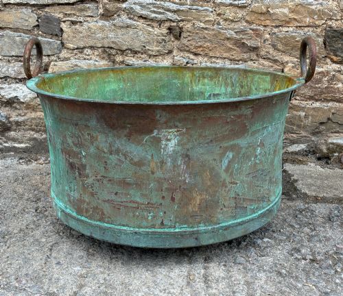 fig 1. A large circular antique copper wash tub displaying heavy green verdigris oxidisation and two iron side handles.