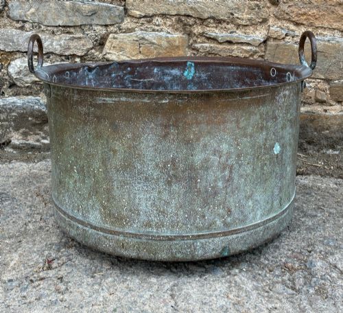 fig 1. A large cylindrical antique copper wash tub featuring a flared rolled rim, side handles, and a heavily aged green verdigris patina.