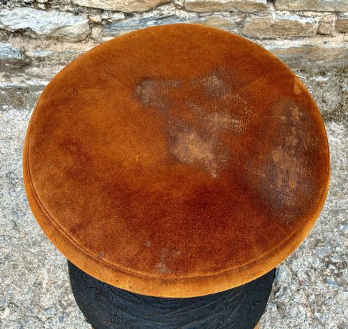 fig 1. An antique taxidermy elephant foot converted into a footstool, featuring dark textured hide with preserved base toenails and a cushioned tan suede seat.
