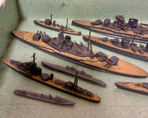 fig 2. A vintage green cardboard box containing a set of miniature diecast metal model warships of the British Navy.
