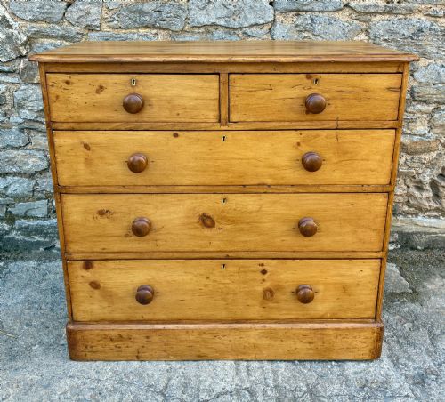 fig 1. A Victorian pine chest of drawers featuring a two short over three long drawer arrangement with turned wooden knobs.