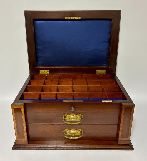 fig 1. An Edwardian warm brown mahogany collectors box featuring wood inlay, brass drop handles, and a polished lid.