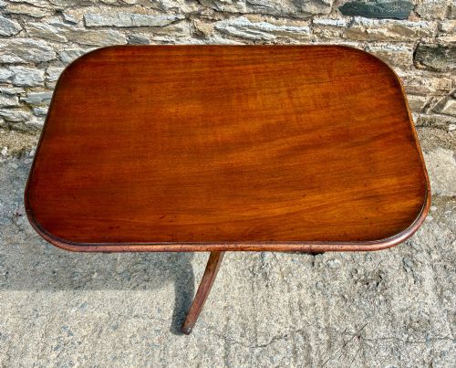 fig 2. A Victorian mahogany tilt-top table featuring a polished rounded rectangular surface set on a turned pedestal column with three splayed legs.