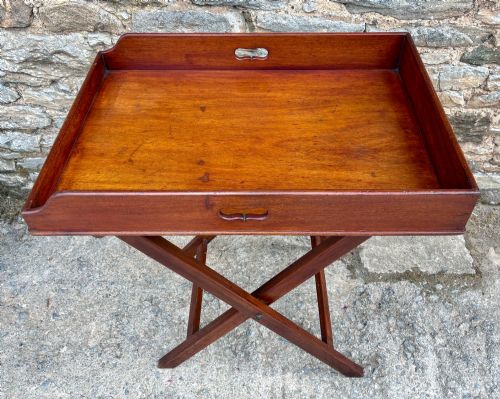 fig 1. A Victorian mahogany butlers tray with cut-out hand holes resting on a folding wooden X-frame stand.