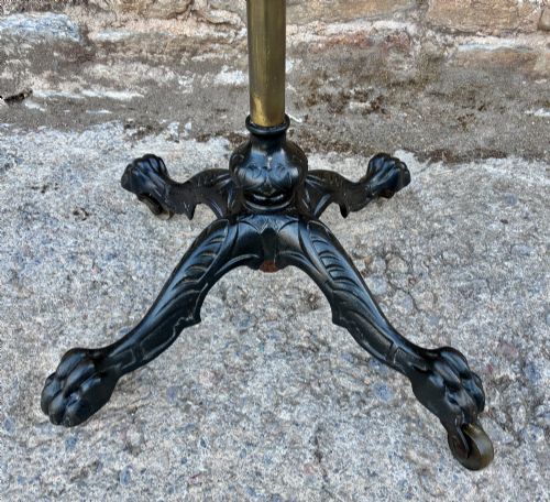 fig 2. Victorian adjustable display stand featuring a round mahogany top, a brass telescoping stem, and a black cast iron paw-foot base.