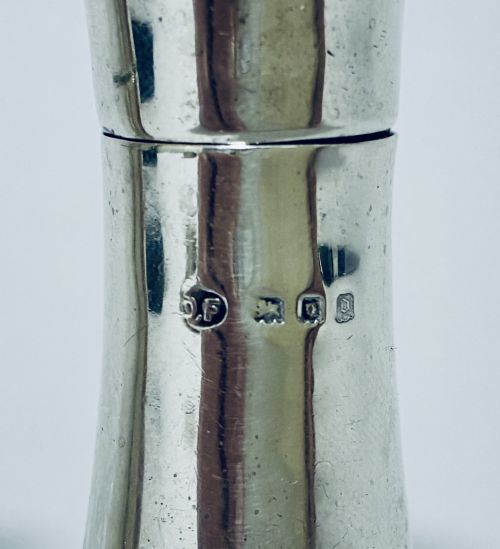 fig 1. A pair of hallmarked sterling silver pepper pots featuring flared bodies, pierced tops, and turned finials.
