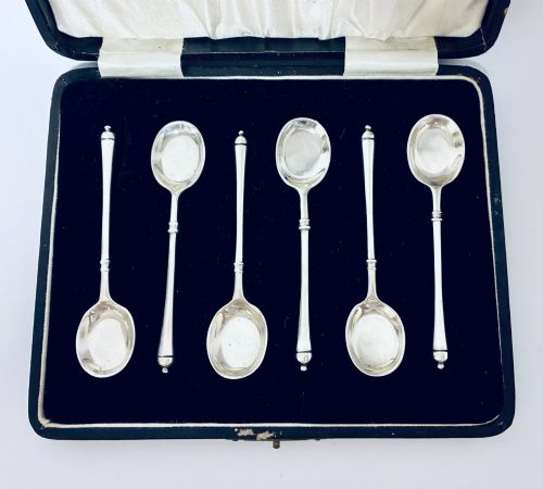 fig 1. A set of six silver coffee spoons with turned handles stored inside a black fitted presentation case lined with velvet and cream satin.