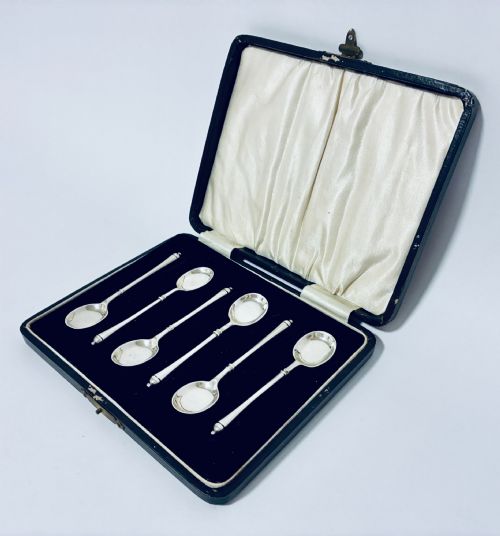 fig 2. A set of six silver coffee spoons with turned handles stored inside a black fitted presentation case lined with velvet and cream satin.
