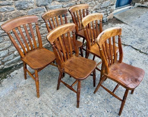 fig 1. A set of six Victorian country dining chairs featuring curved top rails, vertical lathe back slats, shaped solid elm seats, and turned legs.