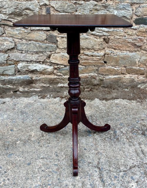 fig 1. A Regency era dark mahogany tilt-top wine table featuring a rectangular surface, turned central pedestal stem, and a splayed tripod base.