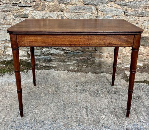 fig 1. A rectangular Georgian mahogany side table featuring rounded top corners and four ring-turned tapered legs.