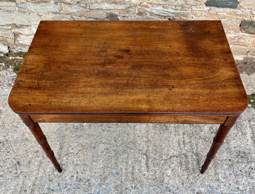 fig 2. A rectangular Georgian mahogany side table featuring rounded top corners and four ring-turned tapered legs.