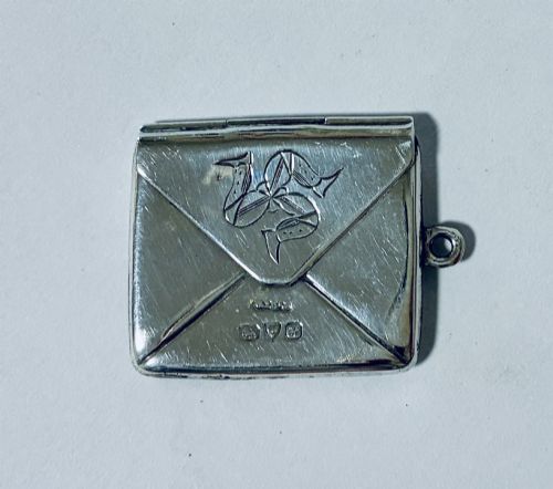 fig 1. An envelope-shaped sterling silver stamp case featuring an engraved Isle of Man triskelion and clear hallmarks.