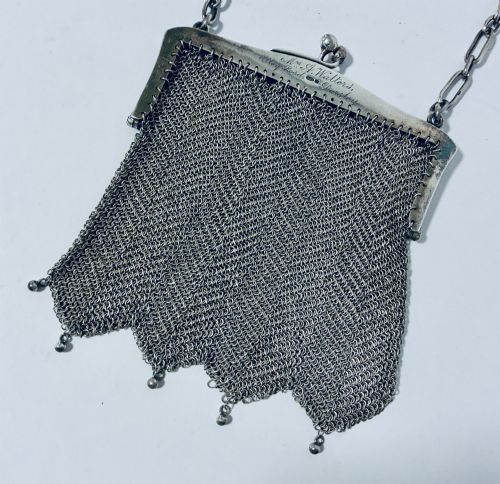 fig 1. An Art Deco silver mesh purse featuring an engraved kiss-lock frame, a paperclip link chain handle, and a scalloped hem with drop-bead detailing.