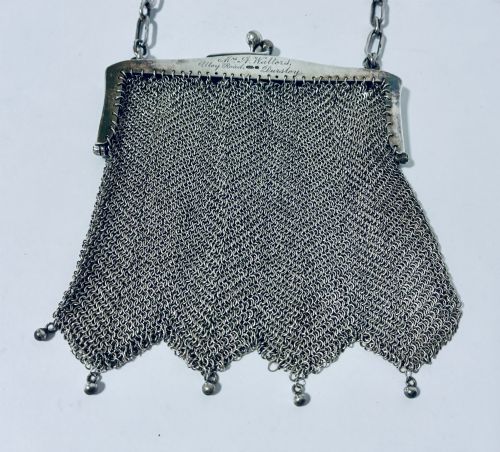 fig 2. An Art Deco silver mesh purse featuring an engraved kiss-lock frame, a paperclip link chain handle, and a scalloped hem with drop-bead detailing.
