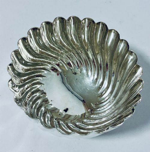 fig 1. An antique silver pedestal bowl featuring spiralled fluted sides and a scalloped rim resting on a round moulded base.