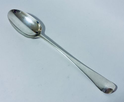 fig 1. An 18th-century silver serving spoon featuring an elongated oval bowl and a smooth tapered handle.