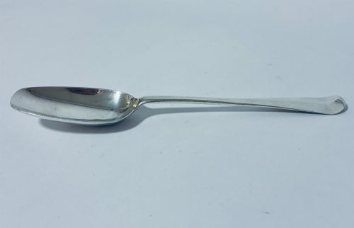 fig 1. An 18th-century sterling silver serving spoon with a wide oval bowl and a smooth stem handle resting on a plain background.