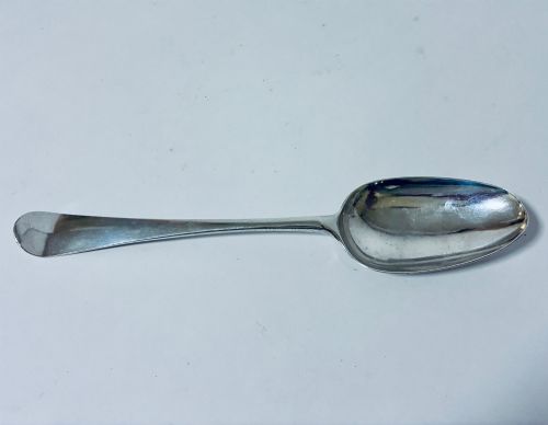 fig 1. An 18th-century solid silver serving spoon featuring a plain tapered handle and an oval bowl.
