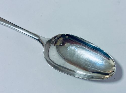 fig 2. An 18th-century solid silver serving spoon featuring a plain tapered handle and an oval bowl.