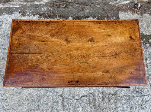 fig 1. A low rectangular warm brown elm blanket box featuring a hinged top, polished finish, brass keyhole escutcheon, and bracket feet.