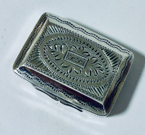fig 1. A small rectangular Georgian sterling silver vinaigrette box featuring bright-cut foliage engraving and a central monogrammed cartouche.