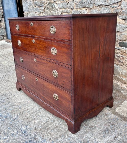 fig 1. A Georgian mahogany chest of drawers featuring four graduated drawers with circular brass ring pull handles and bracket feet.
