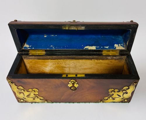 fig 1. A domed Victorian walnut box featuring decorative pierced brass corner mounts and a central brass keyhole.
