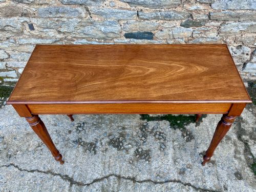 fig 1. A rectangular Victorian mahogany console table featuring a smooth polished top surface, straight apron, and four turned legs.