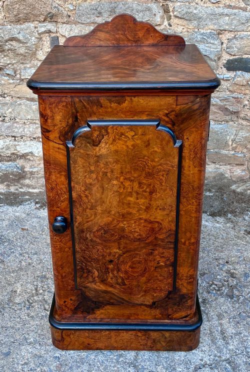 fig 1. A Victorian burr walnut pot cupboard featuring a single door with ebonised moulding, a rounded top edge, shaped splashback gallery, and dark wooden knob.