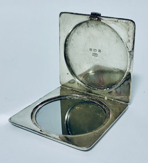 fig 1. A square Art Deco silver powder compact with an engine-turned guilloche surface and a stepped geometric motif.