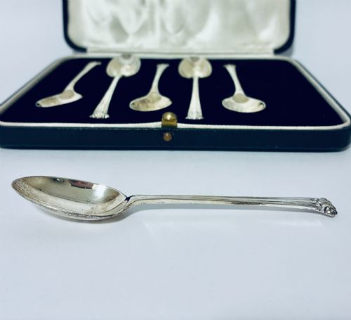 fig 3. A set of six silver teaspoons with decorative reeded handles displayed inside an open fitted presentation case lined in dark velvet and white satin.