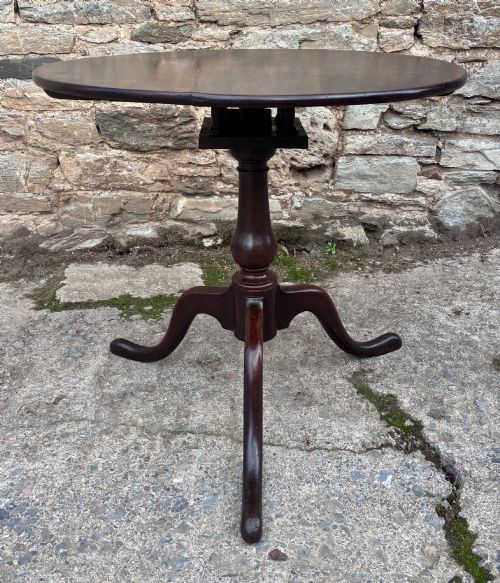 fig 1. A dark brown Georgian oak tilt-top tripod table featuring a circular top, turned baluster column, and three cabriole legs.