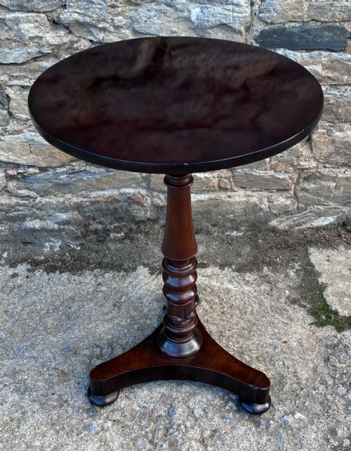 fig 1. A Victorian mahogany wine table featuring a circular top supported by a turned central pedestal column resting on a tripod base.