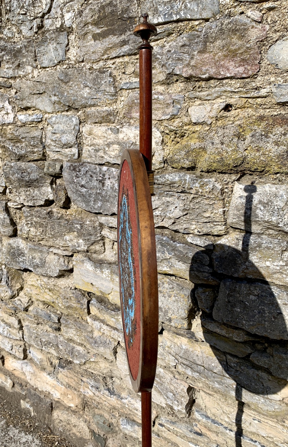 A Regency rosewood pole screen with a circular needlepoint panel on a turned column and triform base. View VIII